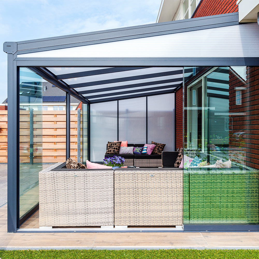 Modern patio canopy with outdoor furniture underneath on a sunny day.