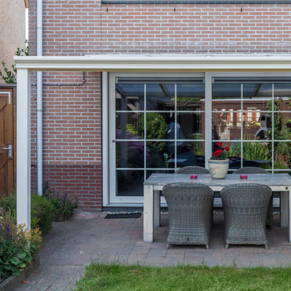 Outdoor dining area with table and chairs in front of a glass door.