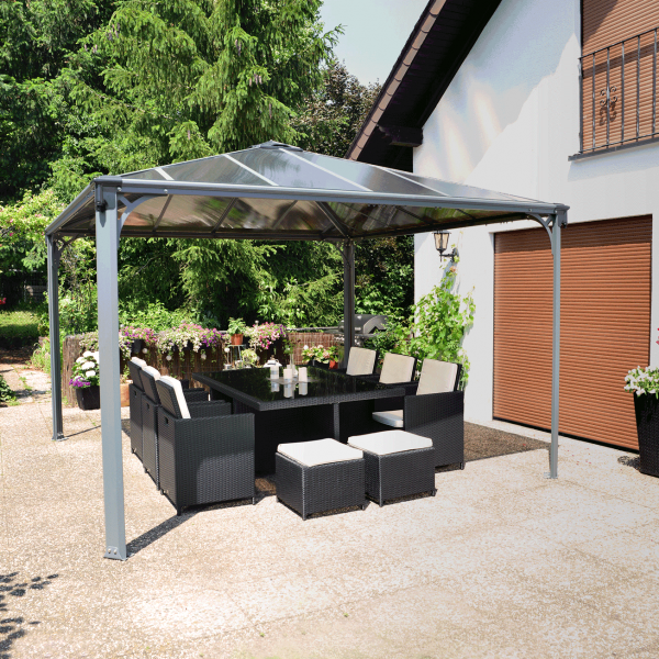 sleek metal gazebo is the focal point of garden sheltering a dining table and chairs