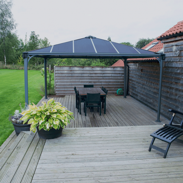 wooden decking with dining set in garden covered by metal gazebo